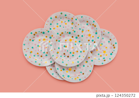 A set of white paper plates with patterns, colored pink and green circles and golden stars. 124350272