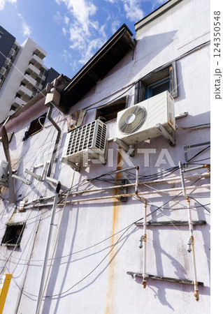 古い老朽化した建物に取り付けられたエアコンの室外機 古い老朽化した建物に取り付けられたエアコンの室外機 124350548