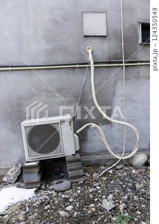古い老朽化した建物に取り付けられたエアコンの室外機 124350549