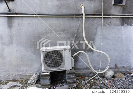 古い老朽化した建物に取り付けられたエアコンの室外機 124350550