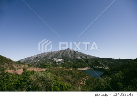 Scenic mountain landscape with reservoir and clear blue sky, La Concepcion reservoir in Marbella 124352148