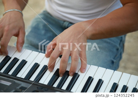 Hands Of A Boy Play The Musical Keyboard Crossing In Rhythm In The Countryside Hands Of A Boy Play The Musical Keyboard Crossing In Rhythm In The Countryside 124352245
