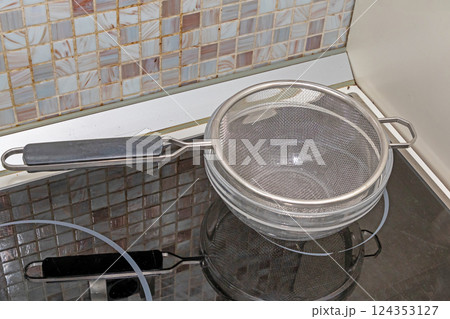 Empty metal strainer in pot 124353127