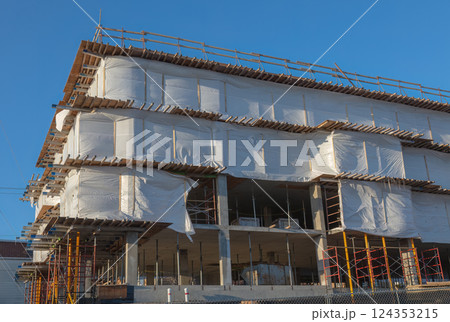 Modern Building Under Construction Wrapped in Protective Sheets 124353215