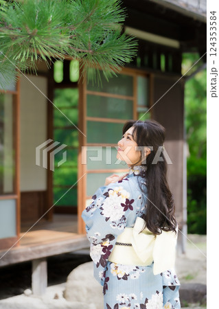 古民家の前で浴衣を着て松を見上げる若い女性の後ろ姿 124353584