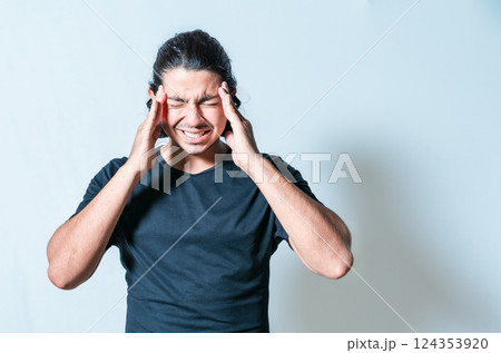 Headache and migraine concept. Suffering man with migraine massaging head isolated Headache and migraine concept. Suffering man with migraine massaging head isolated 124353920