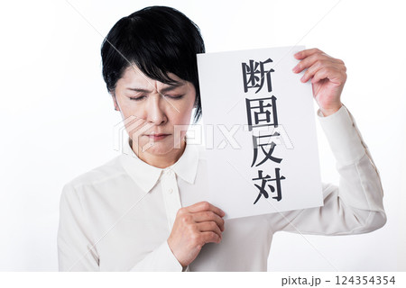 断固反対と書かれた紙を掲げ顔をしかめ眉間に深いシワの寄る中年女性 断固反対と書かれた紙を掲げ顔をしかめ眉間に深いシワの寄る中年女性 124354354
