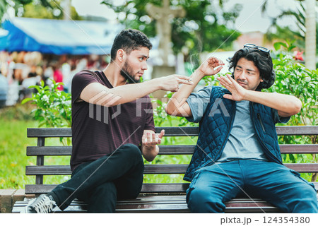 Young man sitting refusing a cigarette in the park. Disgusted guy sitting refusing a cigarette 124354380