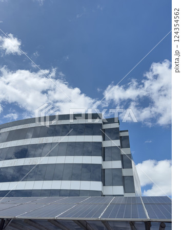 Modern architecture features solar panels against vibrant blue sky in city Modern architecture features solar panels against vibrant blue sky in city 124354562