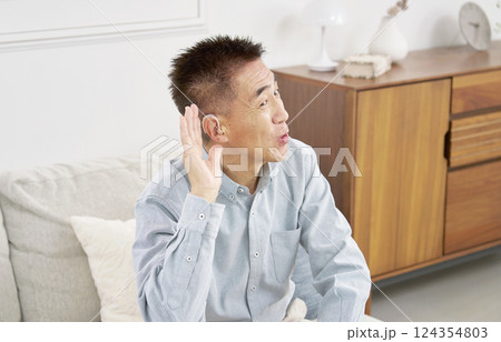 補聴器を付けたシニア男性　リビング 124354803