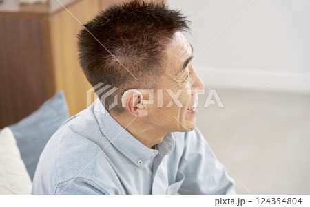 補聴器を付けたシニア男性　リビング 124354804