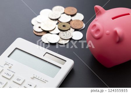 黒背景に貯金箱と硬貨と電卓 124355935
