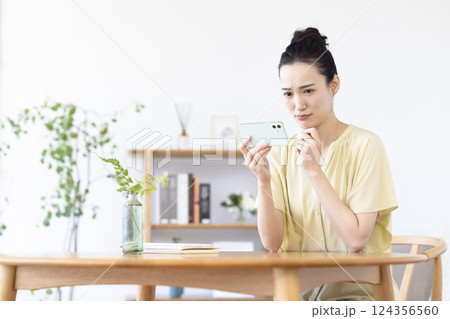 リビングでスマホを見ている女性 リビングでスマホを見ている女性 124356560