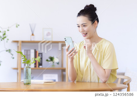 リビングでスマホを見ている女性 124356586