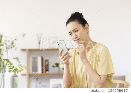 リビングでスマホを見ている女性 リビングでスマホを見ている女性 124356617