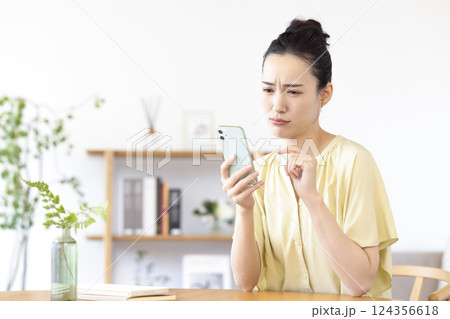 リビングでスマホを見ている女性 リビングでスマホを見ている女性 124356618