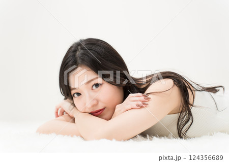 ビューティーイメージ 微笑みながら寝そべる若い女性 カメラ目線 ビューティーイメージ 微笑みながら寝そべる若い女性 カメラ目線 124356689