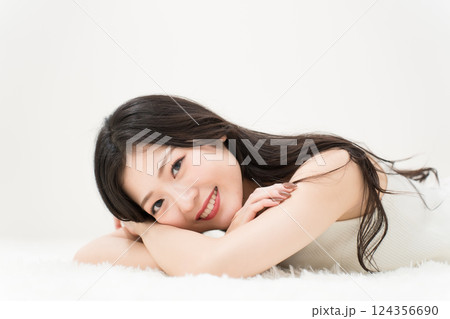 ビューティーイメージ 微笑みながら寝そべる若い女性 カメラ目線 ビューティーイメージ 微笑みながら寝そべる若い女性 カメラ目線 124356690