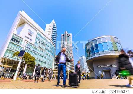 日本の東京都市景観夏のような暑さに脱コート増。キャリーケースの外国人…。黄砂か、青空なのに少し霞む 124356874