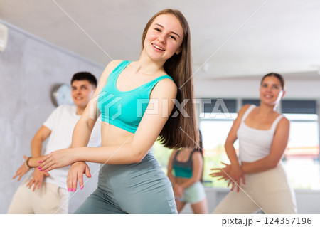 Girl teen perform choreographic exercise and teach energetic house dance with friends Girl teen perform choreographic exercise and teach energetic house dance with friends 124357196