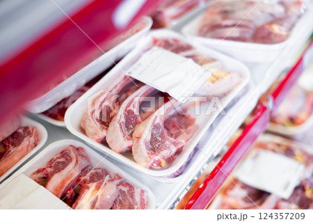 Packaged mutton meat laid out on display shelves of butcher store 124357209