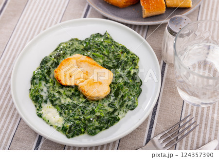 Baked chicken fillet with spinach stewed in bechamel sauce Baked chicken fillet with spinach stewed in bechamel sauce 124357390