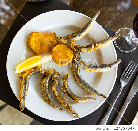 Dish with fried sardines, pilchards or anchovies in batter for traditional Spanish meal 124357947