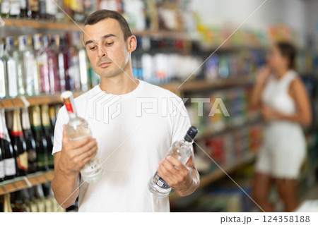 Young man choosing vodka in store 124358188