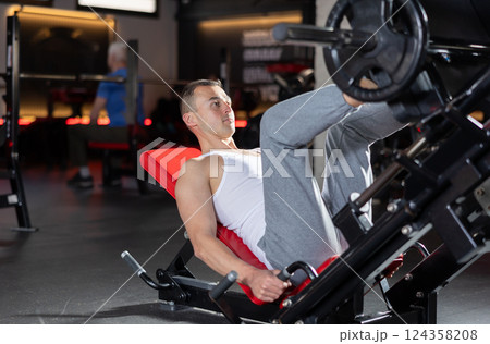 Athlete pulls his legs to his chest on special simulator Athlete pulls his legs to his chest on special simulator 124358208