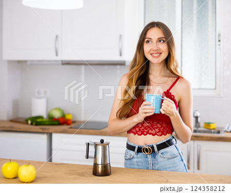 Portrait of laughing woman posing near table with cup of coffee Portrait of laughing woman posing near table with cup of coffee 124358212