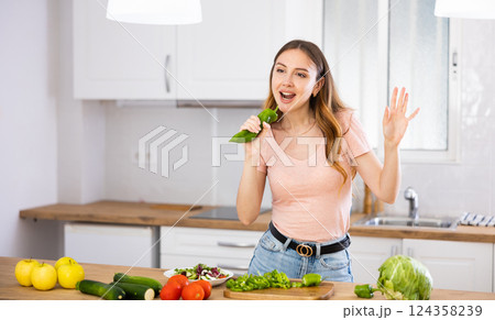 Woman having fun while cooking salad at home Woman having fun while cooking salad at home 124358239
