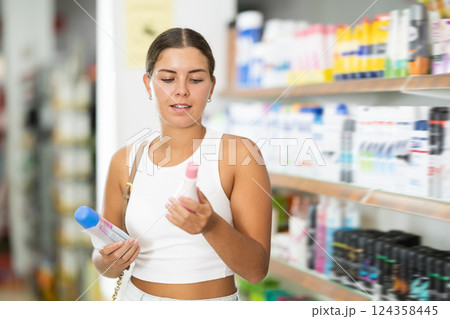 Young woman choosing cosmetics in store Young woman choosing cosmetics in store 124358445