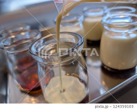 プリン液をガラスの容器に注いでいる様子 プリン液をガラスの容器に注いでいる様子 124359103