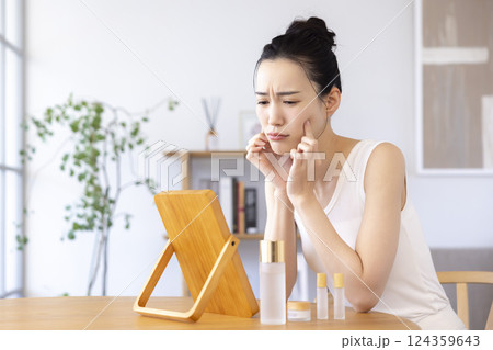 ライフスタイル　鏡を見ながらスキンケアをしている女性 124359643
