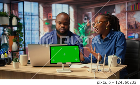 African American couple browse troubleshooting guide next to chroma key, working together to debug router issues and restore their home network. Freelancers getting angry. Camera A. 124360232