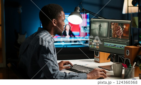 African american videographer works on editing film footage at home, doing freelance contract for post production scenes. Editor correcting white balance and color grading, pc software. Camera B. 124360368
