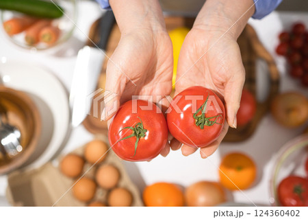 新鮮なトマトを持つミドル女性の手 新鮮なトマトを持つミドル女性の手 124360402