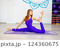 Woman practicing advanced yoga pose on a purple mat  124360675