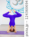 Woman performing a yoga headstand pose in a studio 124360694