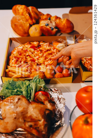 Happy young friends group having lunch at home. Asia family party eating pizza food and laughing enjoying meal while sitting at dining table together at house. Celebration holiday and togetherness. 124361429