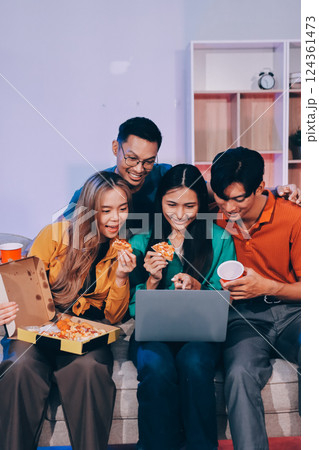 Happy young friends group having lunch at home. Asia family party eating pizza food and laughing enjoying meal while sitting at dining table together at house. Celebration holiday and togetherness. 124361473
