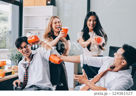 Asian office colleagues and friends enjoy a daytime BBQ with pizza and beer, celebrating Halloween and cheering for their favorite soccer team, creating a lively atmosphere filled with joy. 124361527