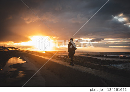 海と夕焼けと女性 124361631