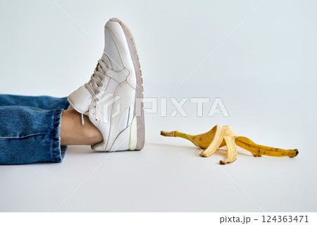 Person slips and falls on banana peel 124363471