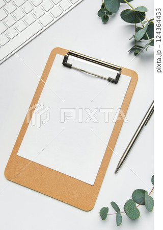 Clipboard with blank paper, pen, keyboard and eucalyptus branches Clipboard with blank paper, pen, keyboard and eucalyptus branches 124364433