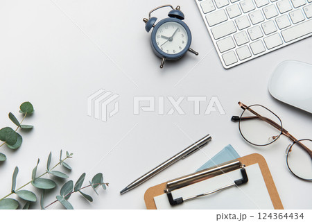 Workspace organizing eucalyptus branches, keyboard, mouse, alarm clock, clipboard, pen Workspace organizing eucalyptus branches, keyboard, mouse, alarm clock, clipboard, pen 124364434