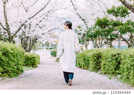 桜並木を散歩する若い女性の後ろ姿 124364484
