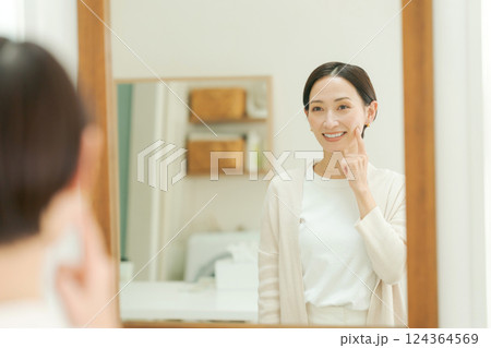 洗面所で鏡を見るミドル女性 124364569