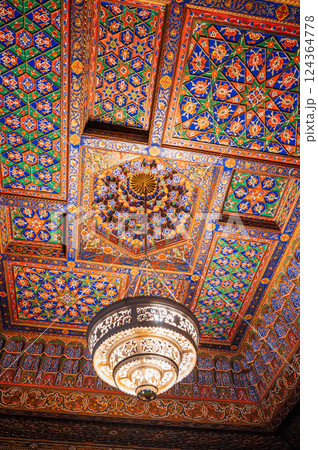 carved wooden painted ceiling with vintage chandelier in the Museum of Art of Uzbekistan with traditional Uzbek ornaments and oriental patterns carved wooden painted ceiling with vintage chandelier in the Museum of Art of Uzbekistan with traditional Uzbek ornaments and oriental patterns 124364778