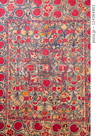traditional Uzbek asian pattern on ancient handmade carpet in Uzbekistan. Oriental background with beautiful ornaments 124364801